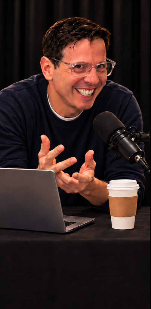 Adam C. Dolgin, founder of The Mentaur™, smiling and gesturing at a podcast microphone beside a laptop and coffee cup
